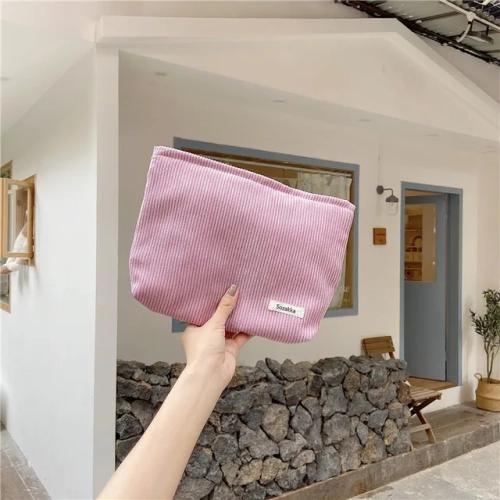 A portable corduroy travel cosmetic bag for women - a large-capacity zipper makeup organizer that doubles as a storage clutch.