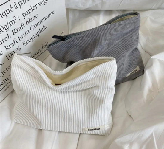 A portable corduroy makeup bag for women with a large capacity. Features a zipper for convenient storage, serving as both an organizer and a storage clutch.