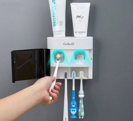 Automatic toothpaste squeezer with magnetic toothbrush holder, wall-mounted for bathroom convenience.